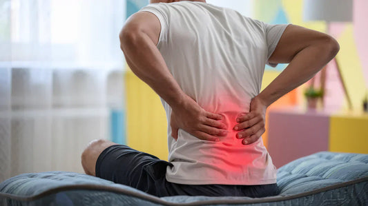 Man sitting on bed having lower back pain 